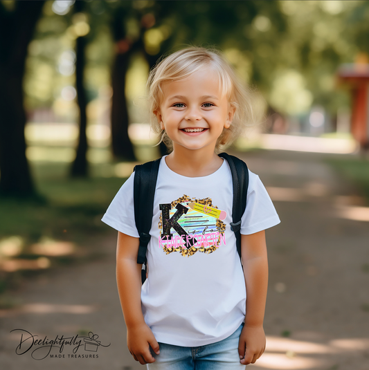 Girl wearing a white K is for Kindergarten design Bella + Canvas shirt.